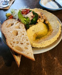 Bread and hummus on a white plate on a wooden table in a restaurant 