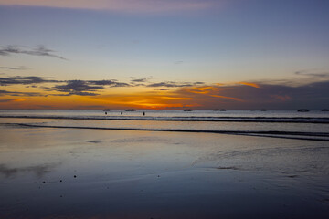 Fototapeta premium Beautiful colourful sunset on Kuta Beach on the island of Bali blue purple orange skies with turquoise blue waters and silhouette of people on the sandy beach the land of gods Bali Island Indonesia 