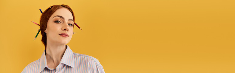 Obraz premium Creative expression of a beautiful young woman with pencils in her hair against a vibrant backdrop