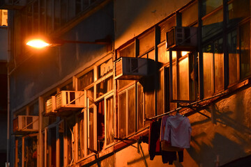 Close-up of the residential building in Hong Kong at night. Building exterior. Hong Kong cityscape, street scene. Travel and cityscape concept.