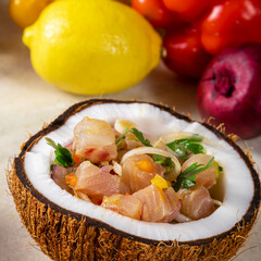 Ceviche dish - appetiser of fresh fish marinated in citrus with tropical fruits served in a Coconut Bowls