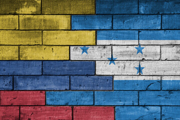 Fototapeta premium colourful painted big national flag of honduras and flag of colombia on a massive old brick wall background. concept