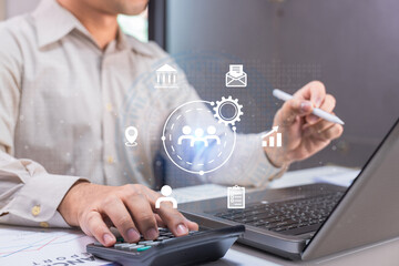A professional uses a laptop and calculator with digital business and data icons overlayed, representing modern business management and analytics.