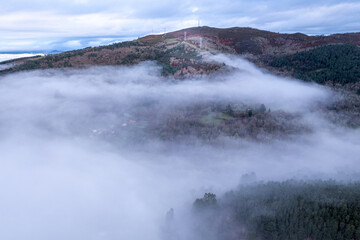 exploring the unknown aerial journey over a fog shrouded landscape, aerial drone image