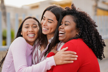 Group of happy diverse latin women having fun hugging each other outdoor - Travel, vacation and...
