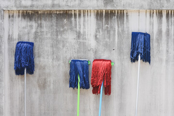 Blue and red mop on white wall