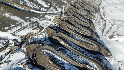 Foto aérea de Los Caracoles, Chile, mostrando a sinuosa estrada montanhosa rodeada por paisagens áridas e rochosas. Destaque para curvas fechadas e cenário natural típico da região © RNL Fotografia