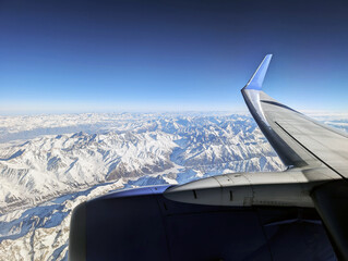 Snow-capped mountains seen from airplane window