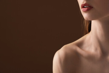 Woman with perfect skin on brown background, closeup. Space for text