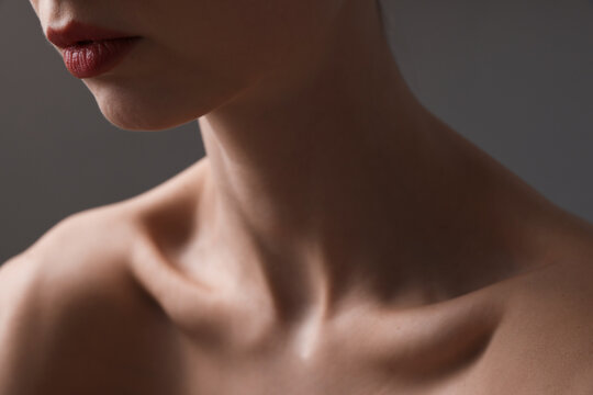 Woman with perfect skin on grey background, closeup