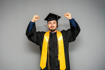 Happy graduate raising arms celebrating graduation day