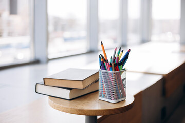 Office supplies with books on wooden table in sunlight
