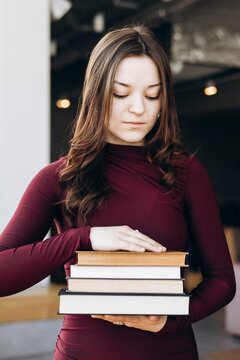Female student holding stack of books