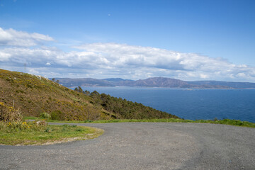 Finisterre, Galicia, Spain; April 6, 2025:  Panoramic shot from Mirador de Fisterra featuring the Atlantic horizon, steep cliffs, and the Finisterre lighthouse.  Atlantic coast. 