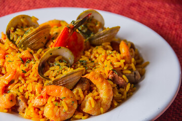 A vibrant seafood paella showcasing a medley of shrimp, clams, and aromatic rice, beautifully garnished to highlight its exquisite culinary presentation and vibrant colors.
