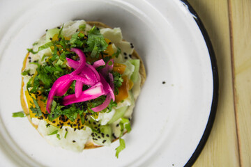 An eye-catching tostada beautifully adorned with a variety of fresh toppings, emphasizing the...