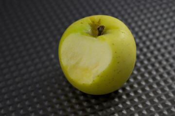 This image displays a crisp green apple with a bite taken out, showcasing its fresh and juicy interior, symbolizing health and natural sweetness in every bite, perfect for snacking.