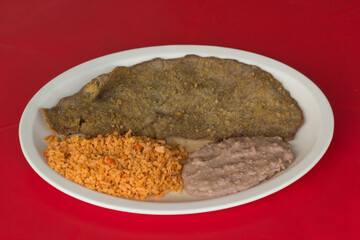 This image features a delicious fried steak served alongside fluffy rice and creamy refried beans on a bright red background, enhancing the appetizing presentation.