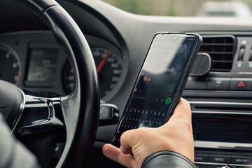 Driver types on smartphone while driving, highlighting the risk and importance of road safety, distraction, and responsible behavior behind the wheel.