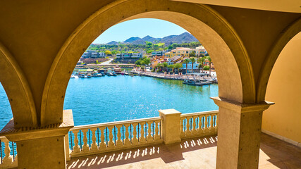 Aerial Fly Through Mediterranean Stone Arches Over Marina and Waterfront Balcony