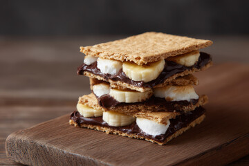 Stacked vegan smores with dark chocolate and banana slices