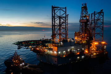 Aerial view of offshore jack up drilling rig during sunset - oil and gas industry.