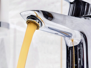 Water flowing from faucet with an unusual yellow color, raising concerns about plumbing issues at...