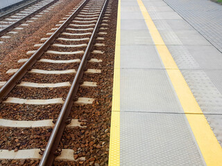 Empty railway station with rail tracks. Train platform