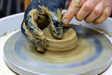Creating a ceramic bowl in a pottery class. Wheel throwing. Learning how to model clay into different shapes with pottery wheel