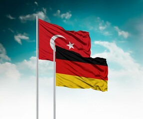  National flags of Turkey and Germany wave side by side in a clear blue sky symbolizing...