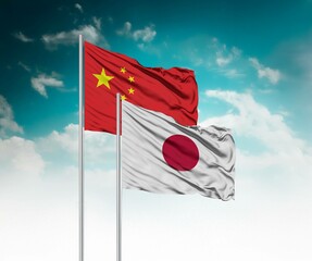  National flags of China and Japan wave side by side in a clear blue sky symbolizing international unity and cooperation.