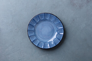Empty blue plate on a grey blue stone background. Copy space. Top view.