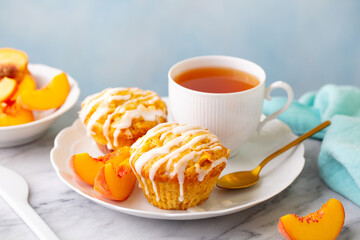 Muffins, peach fruit cupcakes with cup of tea. Grey background. Close up.