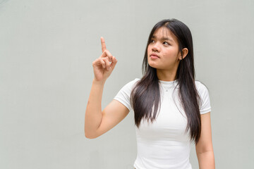 Fototapeta premium young woman pointing and looking up