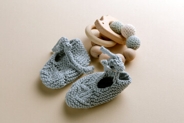 Knitted baby clothes and handmade accessories on neutral fabric in newborn outfit from above