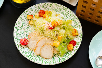 Appetizing Caesar salad with chicken breast, lettuce and toast