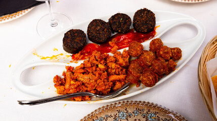 Traditional hot Spanish tapa of blood sausage, chorizo, picadillo and roasted peppers