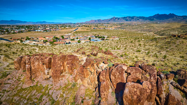 Aerial Desert Rock Formations and Suburban Neighborhood with Mountain Horizon