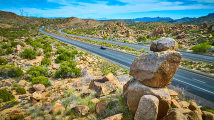 Aerial Desert Highway Motion with Solitary Car and Rocky Boulders Perspective
