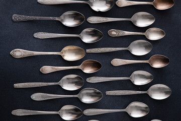 Set of different spoons. Silver cutlery on a black background. Spoon on the table dining serving