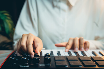 Fototapeta premium Pianist Concept. Person Playing Electronic Keyboard with Focused Expression While Creating Music in a Comfortable Setting