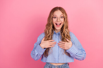 Excited young woman in casual outfit with morning enthusiasm posing on vibrant pink background