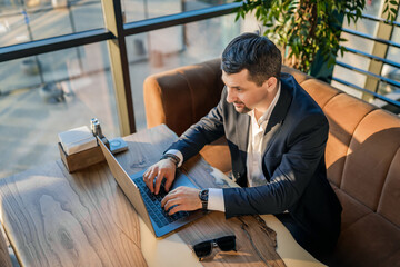 Businessman in a cafe focused on laptop work during daytime