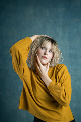 Elegant portrait of a young woman posing in a yellow top