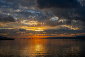 Fiery Sunset Over Industrial Harbor and Calm Sea in Başiskele, Kocaeli, Türkiye with Dramatic Cloudscape and Reflections