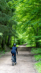 Cyclist Enjoying a Serene Ride Through a Lush Forest Path in Spring