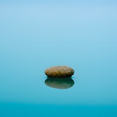 Peaceful River Stone Floating on Turquoise Water with Misty Horizon – Minimalist Nature Background