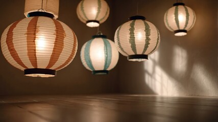 Fototapeta premium Five paper lanterns hang in a room casting light and shadows.