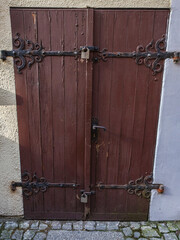 Old wooden door, to the basement, dark brown in color, on metal hinges