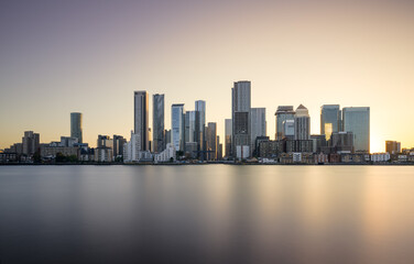 Fototapeta premium Canary Wharf at sunset with the sun backlighting the iconic skyline. Shot from the Greenwich peninsula.